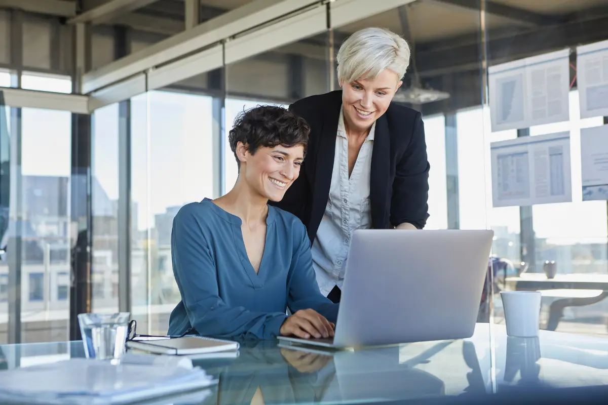 Business advisors helping entrepreneur with company formation incorporation process on laptop in modern office.